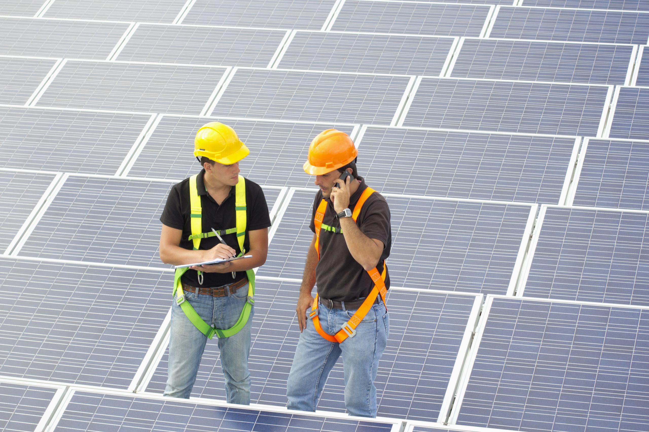 Two workers in between photovoltaic panels, one on the phone receiving instructions, the other taking notes (ISO 160). All my images have been processed in 16 Bits and transfer down to 8 before uploading.